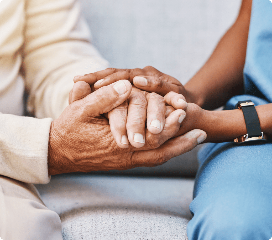 GettyImages-1473155461 Two people holding hands on sofa.